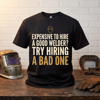 Load image into Gallery viewer, Try Hiring A Bad One welder t-shirt on a workbench with welding helmet and gloves