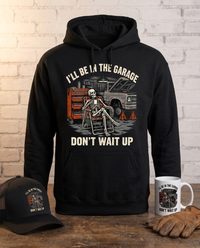 Load image into Gallery viewer, I'll Be In The Garage, Don't Wait Up skeleton hoodie standing on a workbench