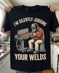 Load image into Gallery viewer, Holding up the Silently Judging Your Welds shirt as a gift